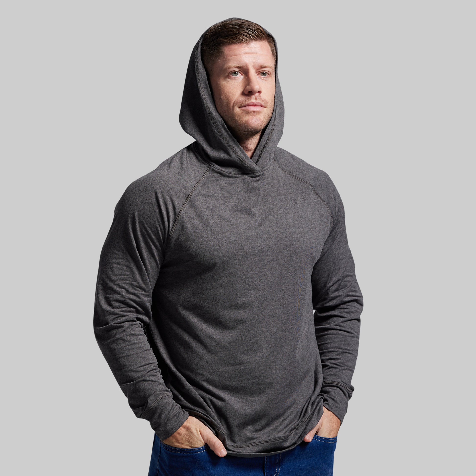 Man wearing a gray hoodie against a plain background