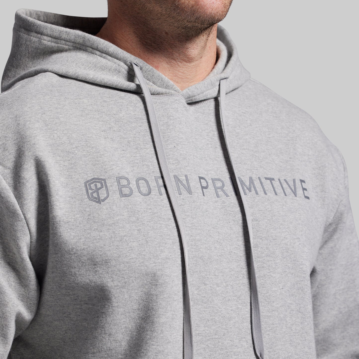 Gray hoodie with 'Born Primitive' logo on a gray background