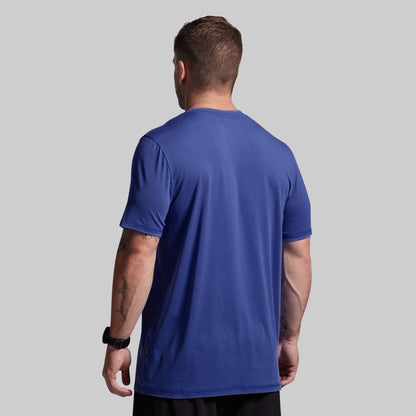 Man wearing a blue t-shirt on a gray background