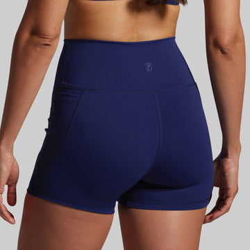 Navy blue athletic shorts worn by a person on a gray background