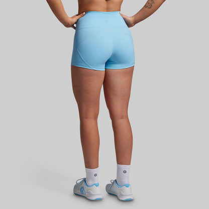 Person wearing light blue athletic shorts on a gray background
