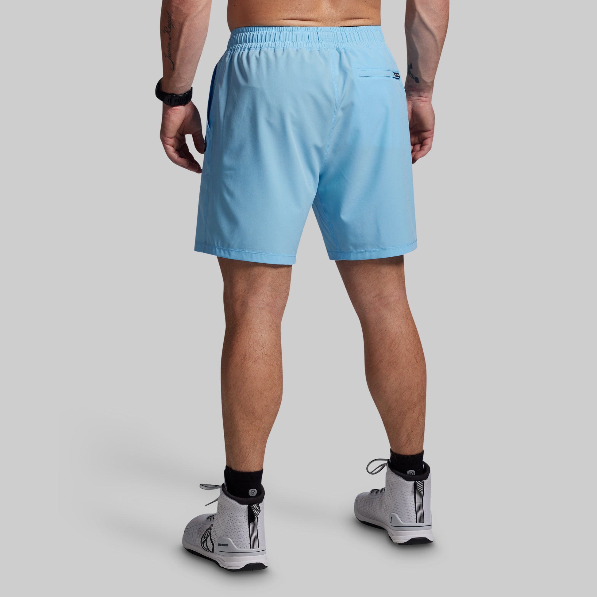 Person wearing light blue shorts on a gray background