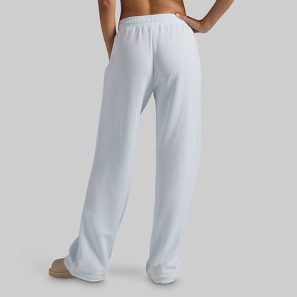 A person shown from the back wearing light blue wide-leg lounge pants against a plain light gray studio background.