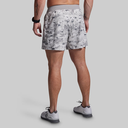 Person wearing patterned shorts on a gray background