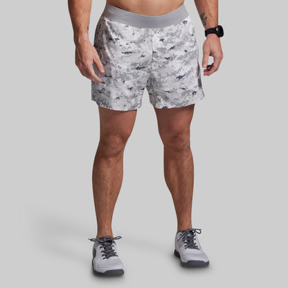 Person wearing gray patterned shorts on a plain background