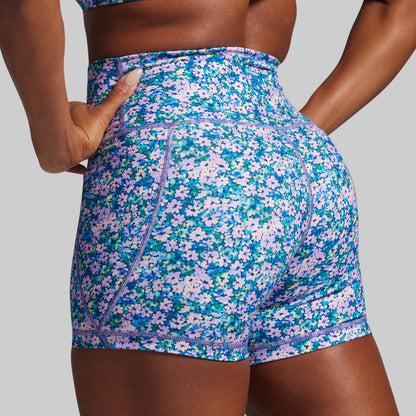 Floral patterned shorts worn by a person on a gray background