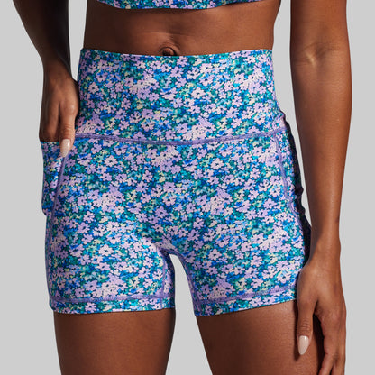 Floral patterned shorts worn by a person on a gray background