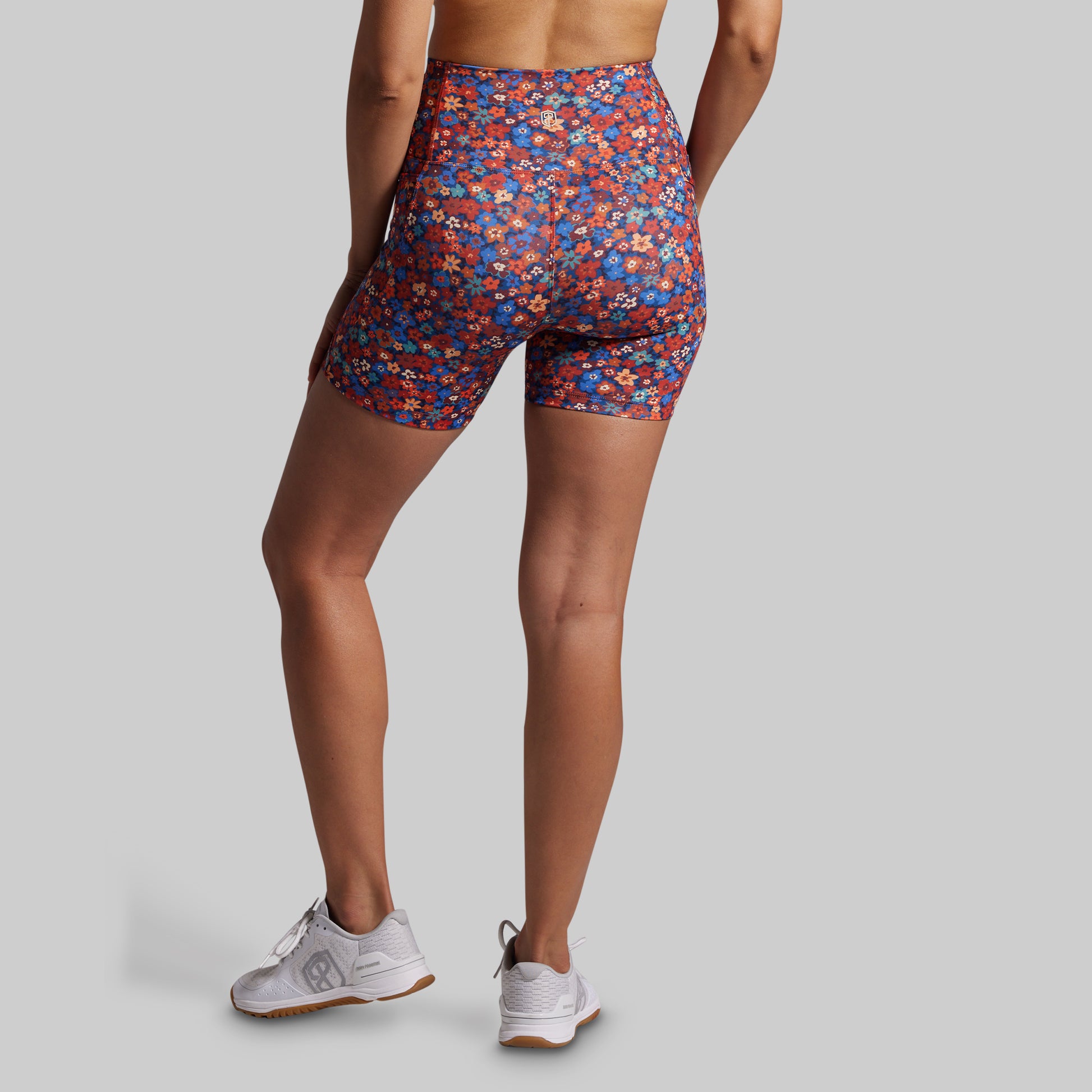 Person wearing colorful patterned shorts on a plain background