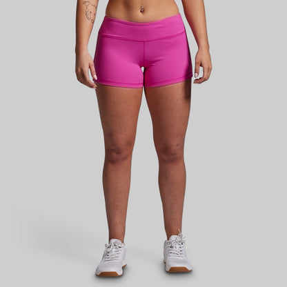 Person wearing bright pink athletic shorts on a gray background