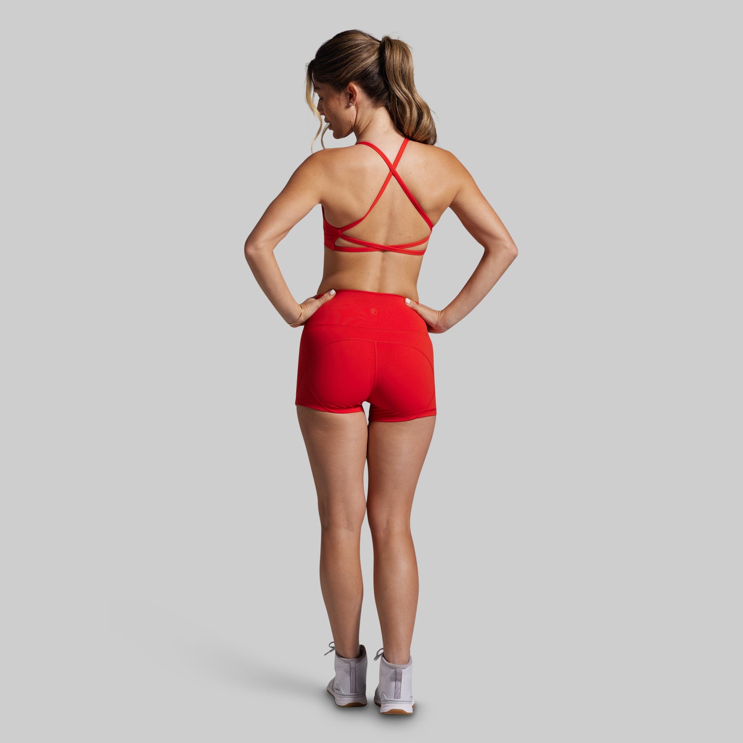 Woman wearing a red sports outfit on a gray background