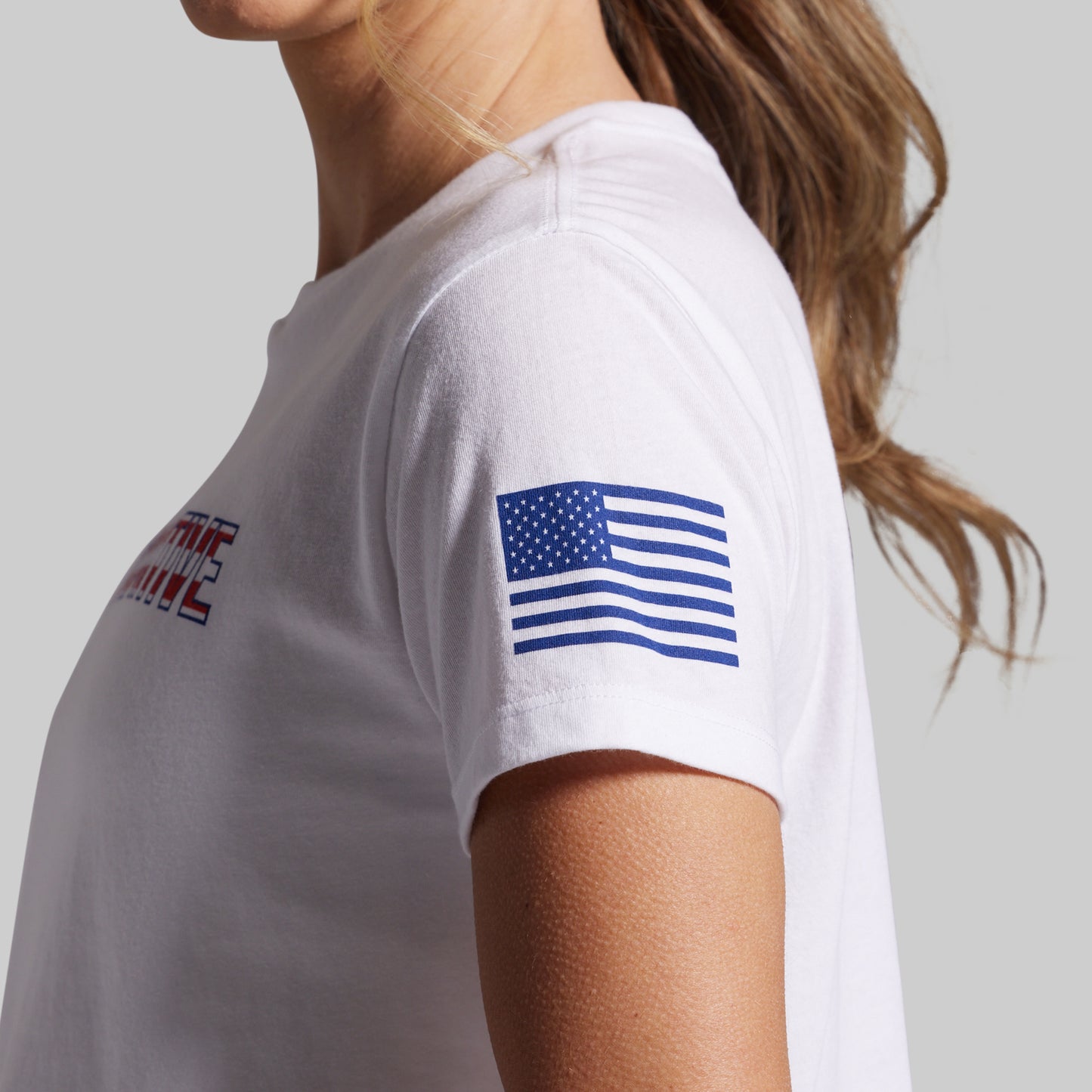 White t-shirt with American flag design on sleeve on a plain background
