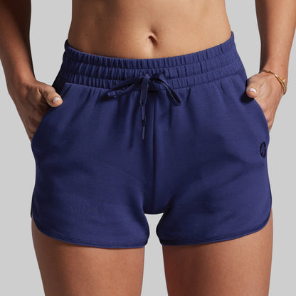 Navy blue shorts with a drawstring on a gray background