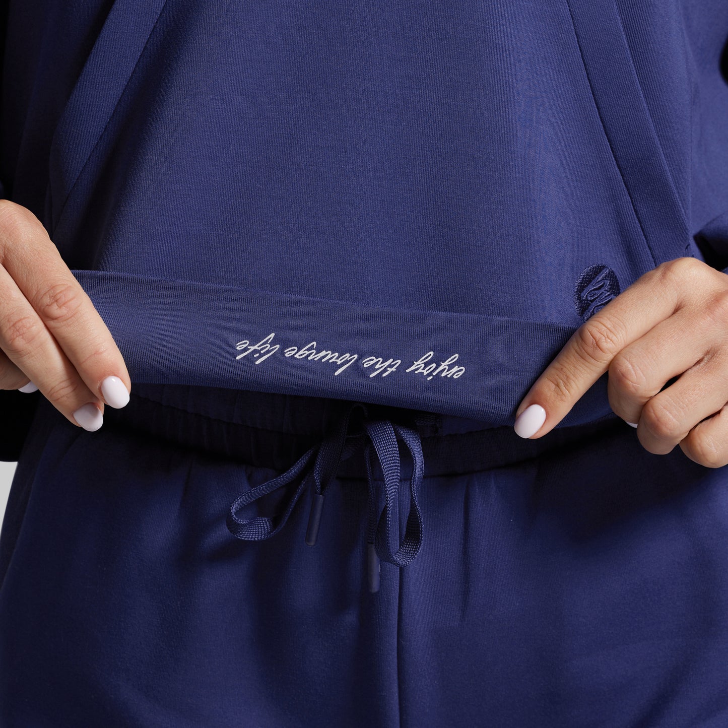 Navy blue garment with text on waistband held by hands