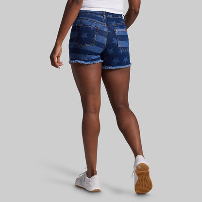 Person wearing blue denim shorts with American flag pattern on a gray background