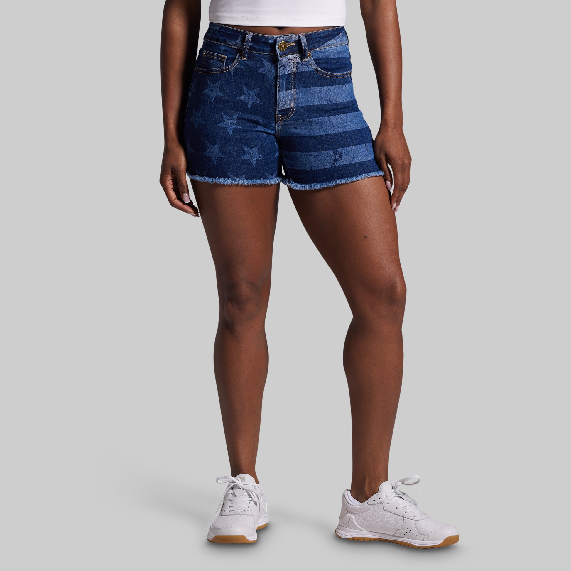 Person wearing blue denim shorts with American flag pattern on a gray background