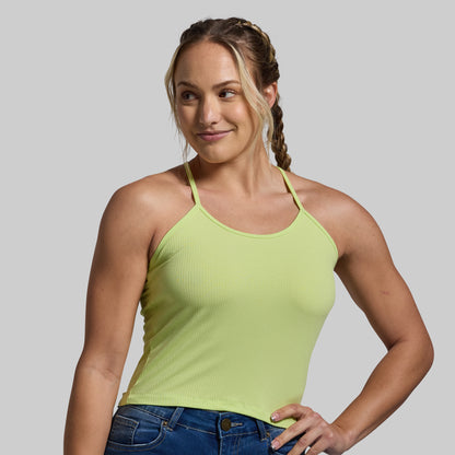 Woman wearing a light green tank top against a plain background
