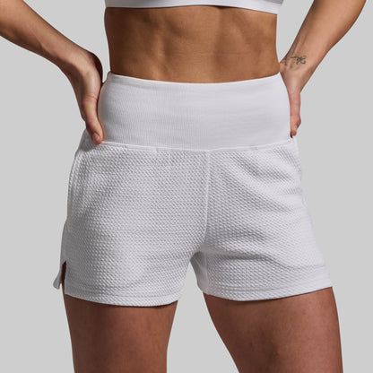 White textured shorts worn by a person on a plain background