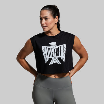 Woman wearing a black sleeveless top with 'Live Free' graphic and gray leggings on a gray background