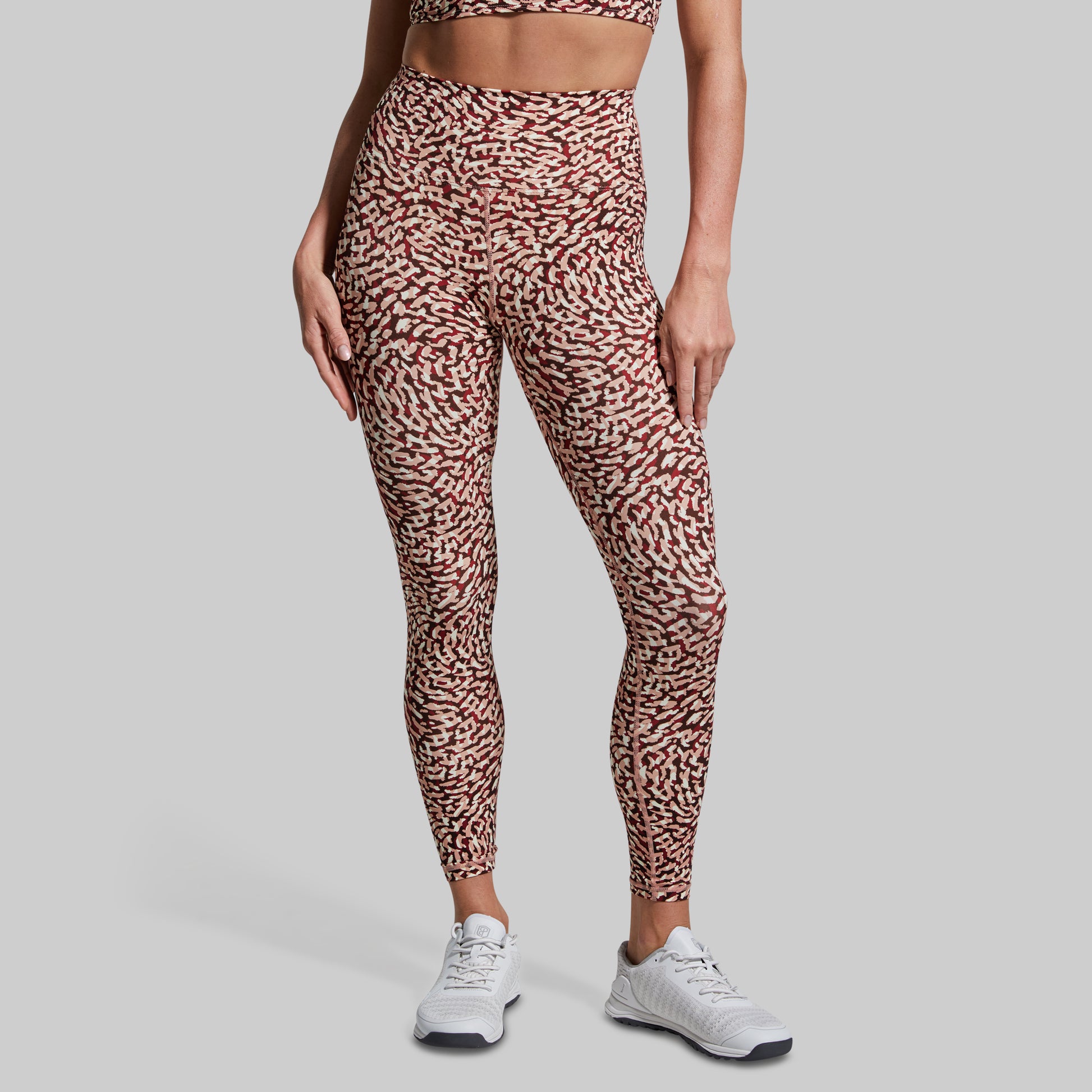 Person wearing leopard print leggings on a gray background