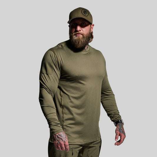 Man wearing an olive green long-sleeve shirt and cap on a gray background
