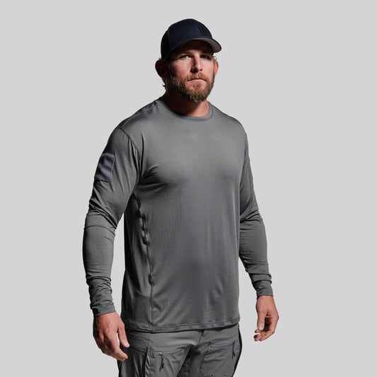 Man wearing a gray long-sleeve shirt and cap on a light gray background