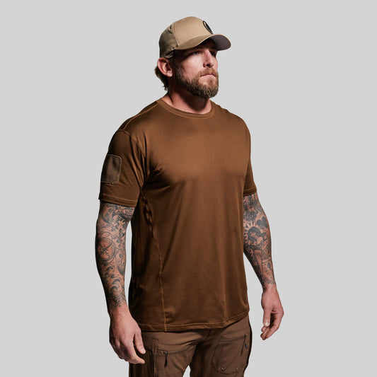 Man wearing a brown t-shirt and cap on a gray background