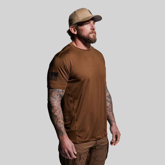 Man wearing a brown t-shirt and cap on a gray background