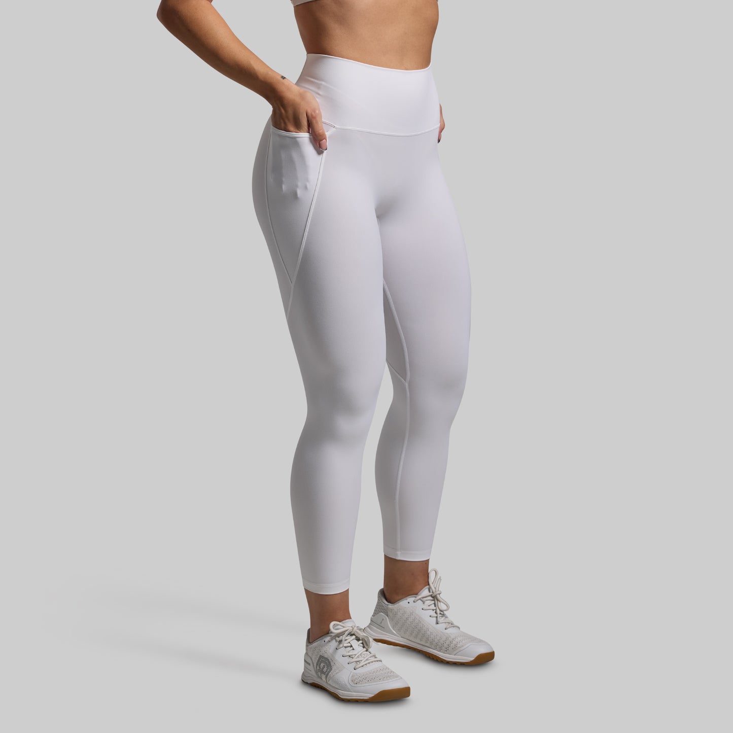 Person wearing white leggings on a plain background