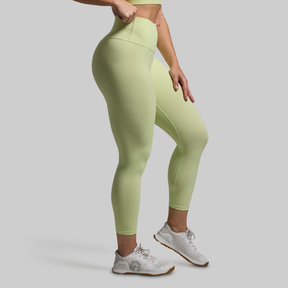 Person wearing light green leggings on a plain background