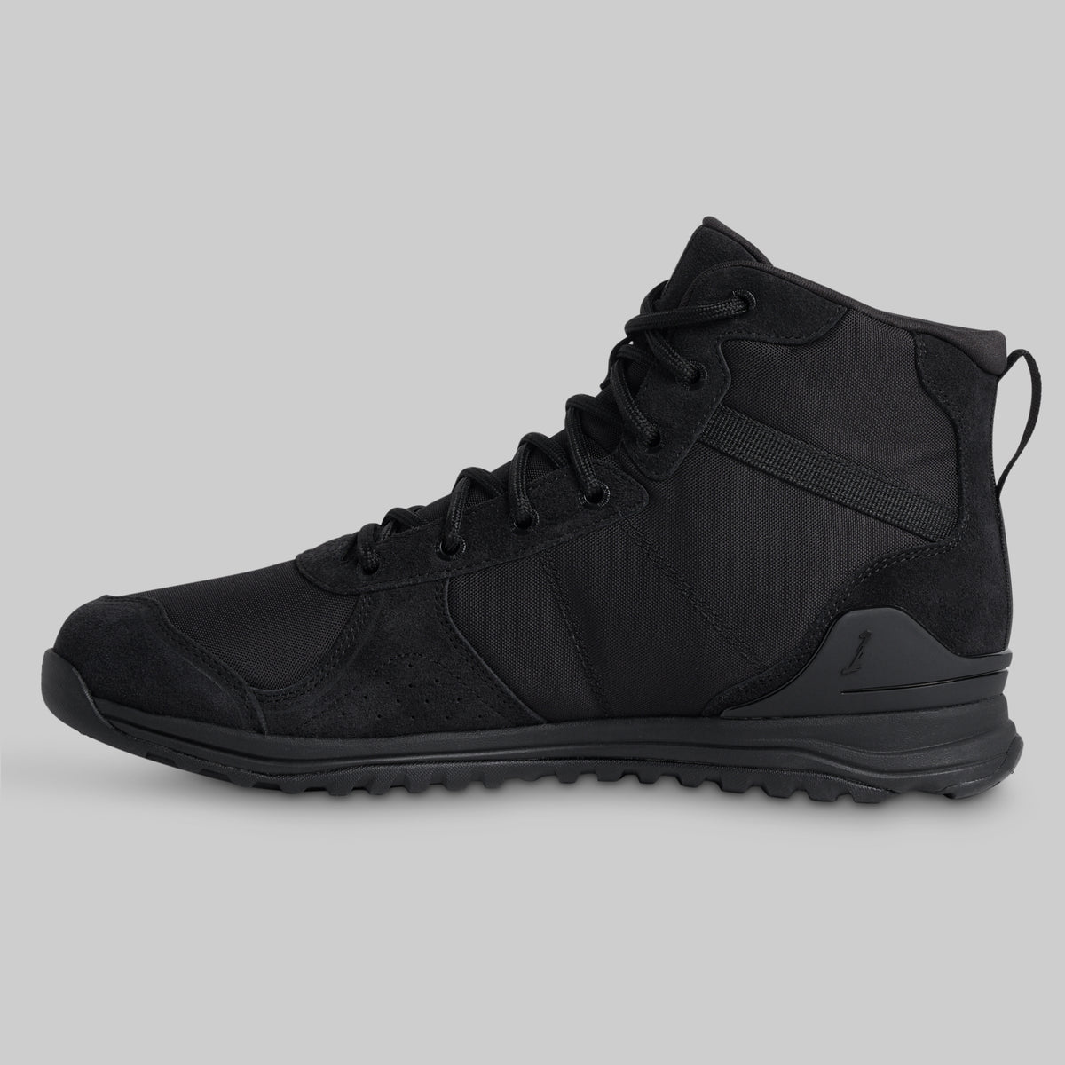Black tactical boot on a gray background