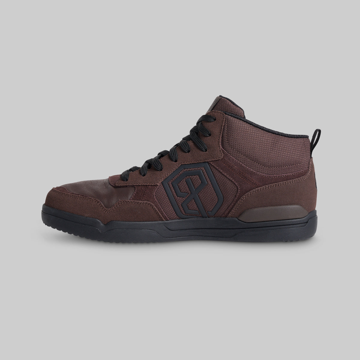 A dark brown high-top sneaker with black laces, a black outsole, and a black geometric logo on the side, shown against a solid gray background.