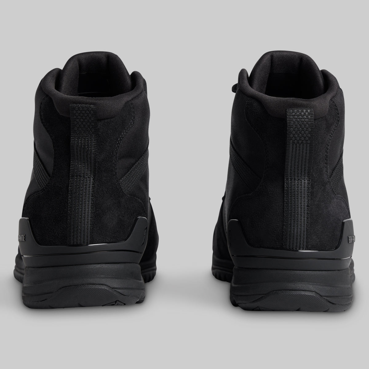 Black tactical boots on a light gray background
