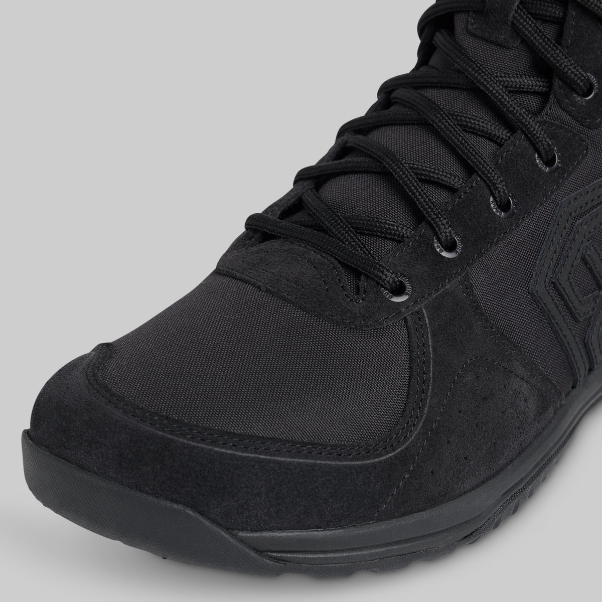 Black tactical boot on a gray background
