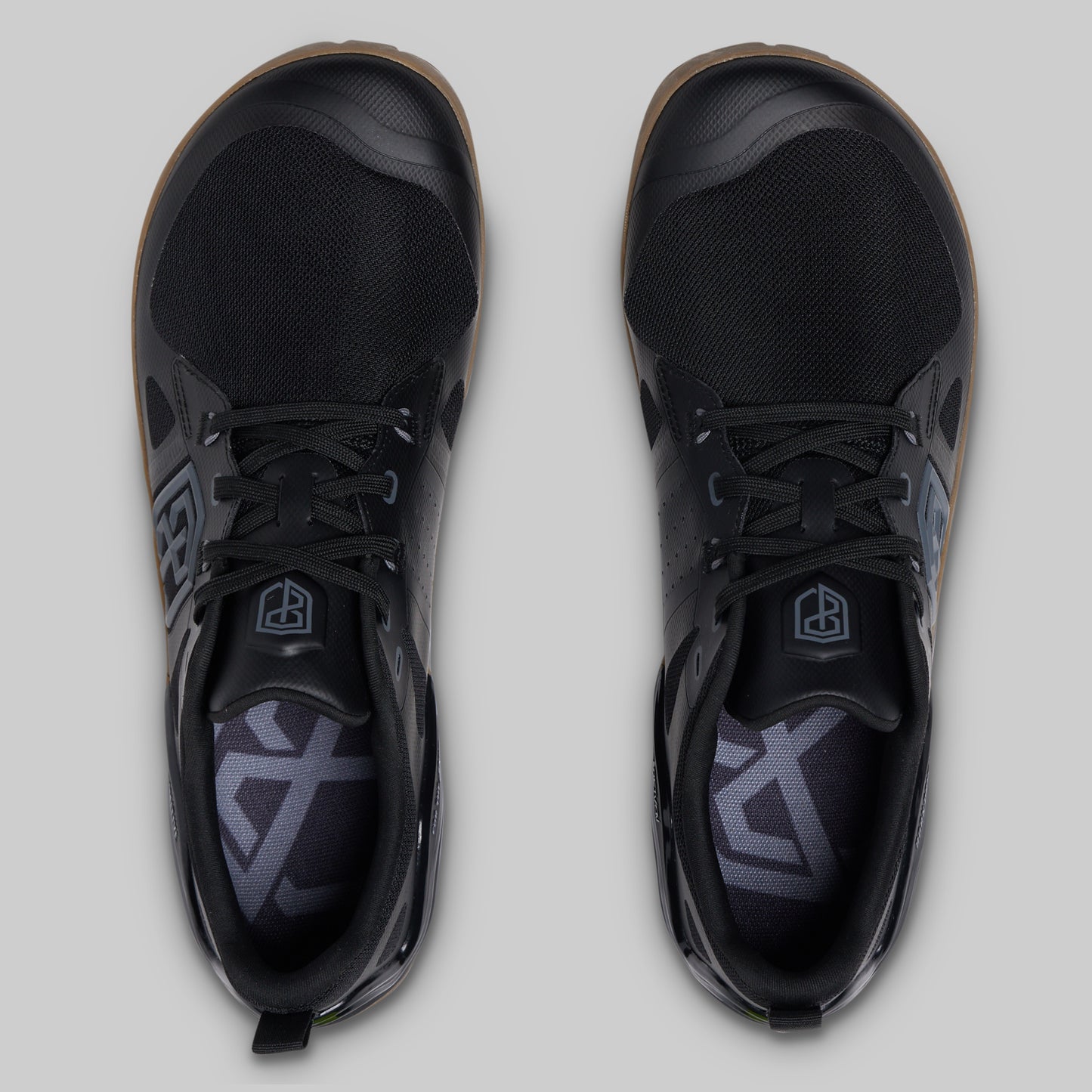 A pair of black low-top athletic shoes shown from a top-down view on a light gray background.