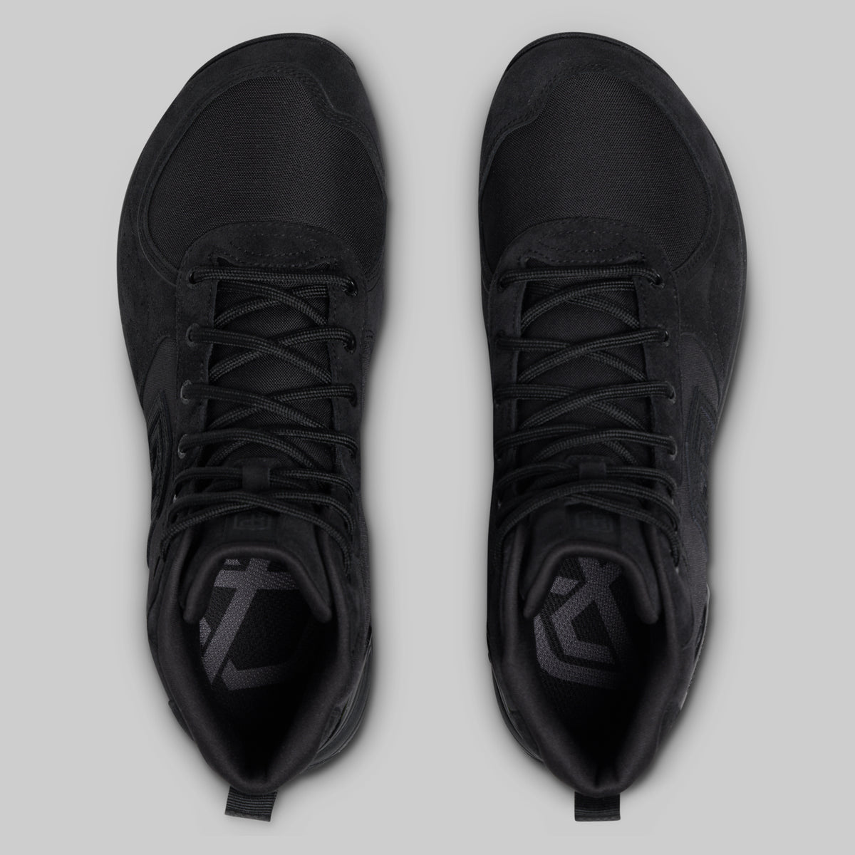 Pair of black high-top tactical boots on a light gray background