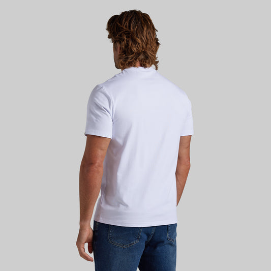 A man viewed from behind wearing a plain white short-sleeve shirt and blue jeans against a solid light gray background.