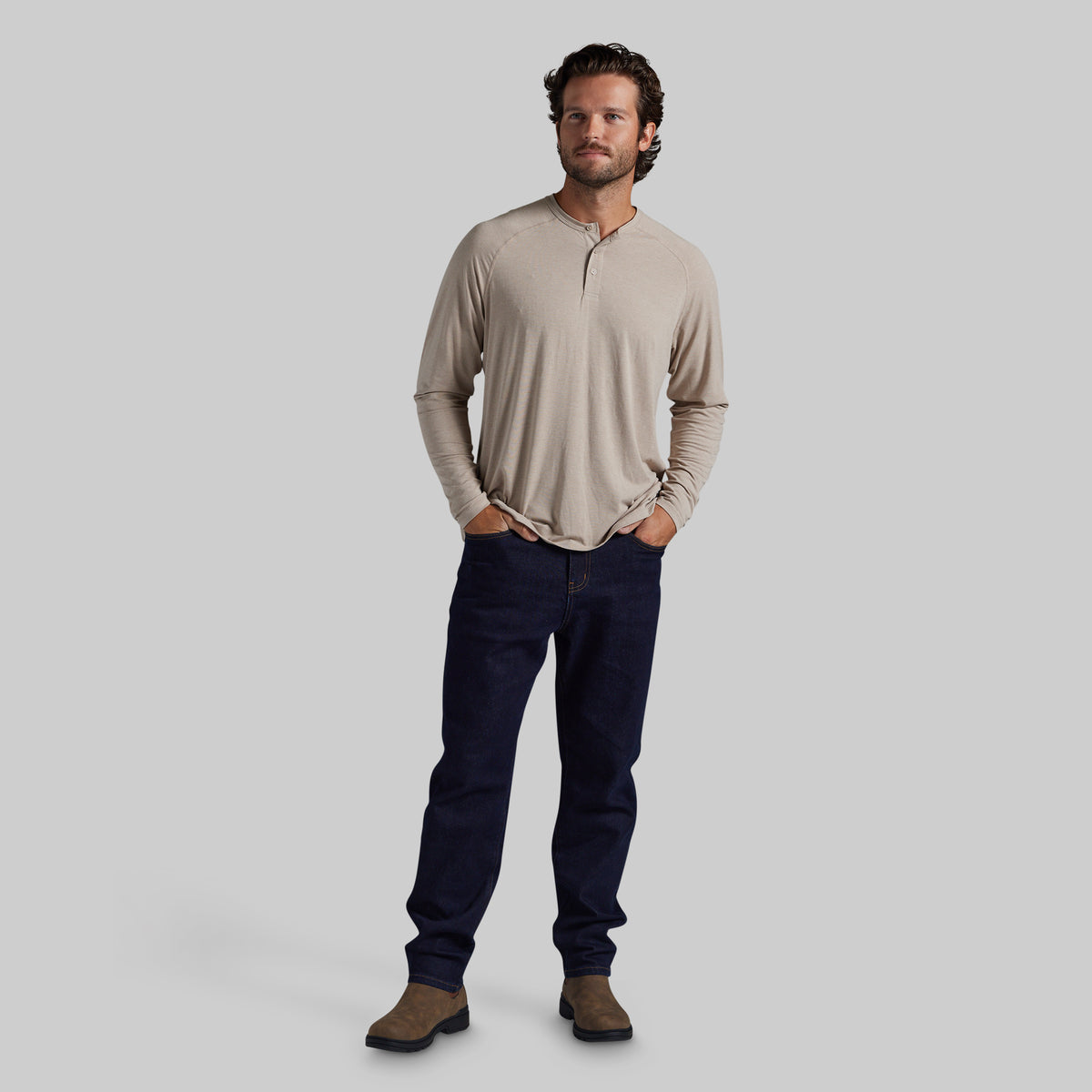 Man wearing a cream long sleeve shirt and dark blue pants