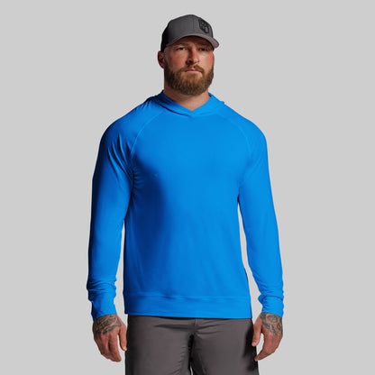 Man wearing a blue hoodie and gray cap on a light gray background