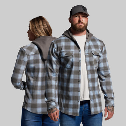 Two people wearing plaid shirts against a plain background