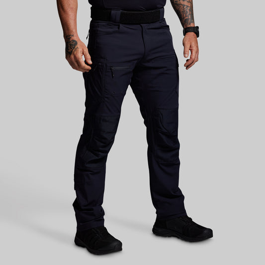 Person wearing dark blue tactical pants on a gray background