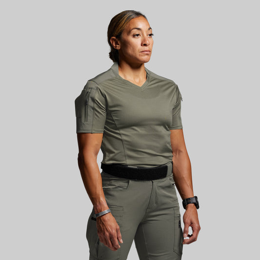 Person wearing a green tactical outfit on a gray background