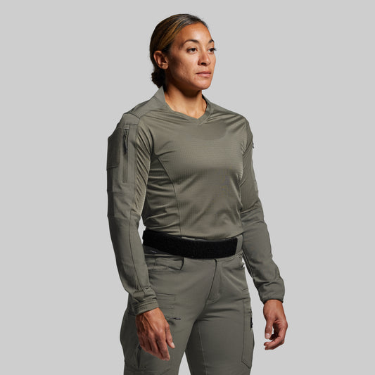 Person wearing a green tactical outfit on a gray background