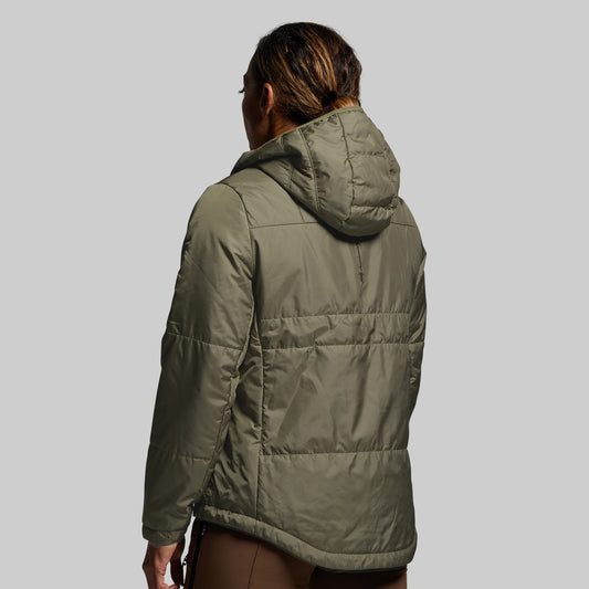 Person wearing a green puffer jacket on a plain background