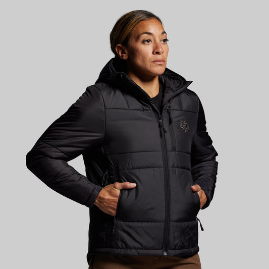 Person wearing a black puffer jacket on a gray background