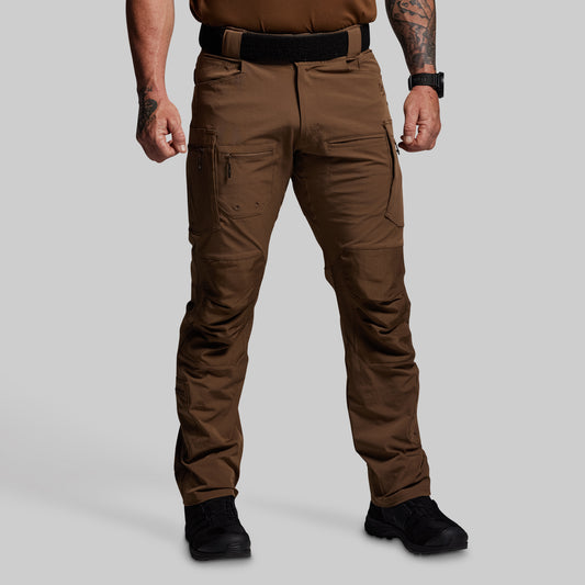 Person wearing brown tactical pants on a gray background