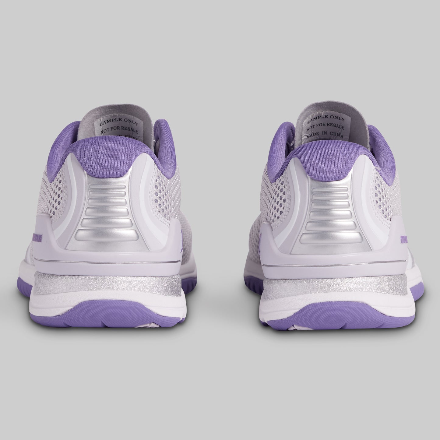 White and purple athletic shoes on a gray background