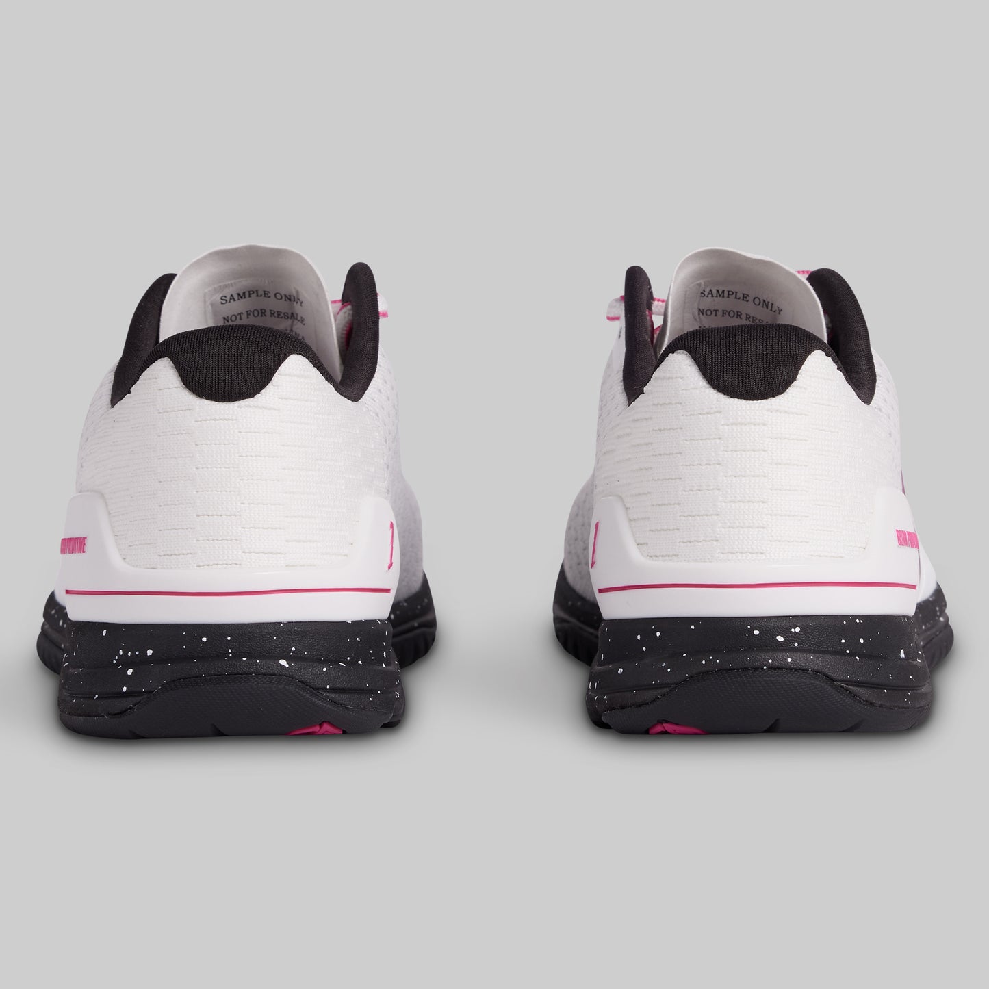 White sneakers with black and pink accents on a gray background