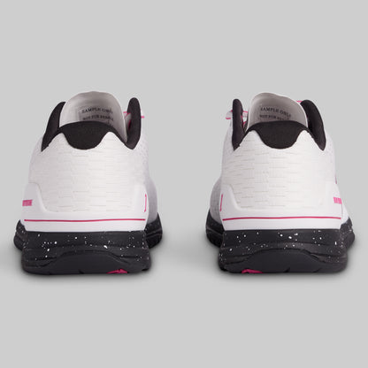 White sneakers with black and pink accents on a gray background