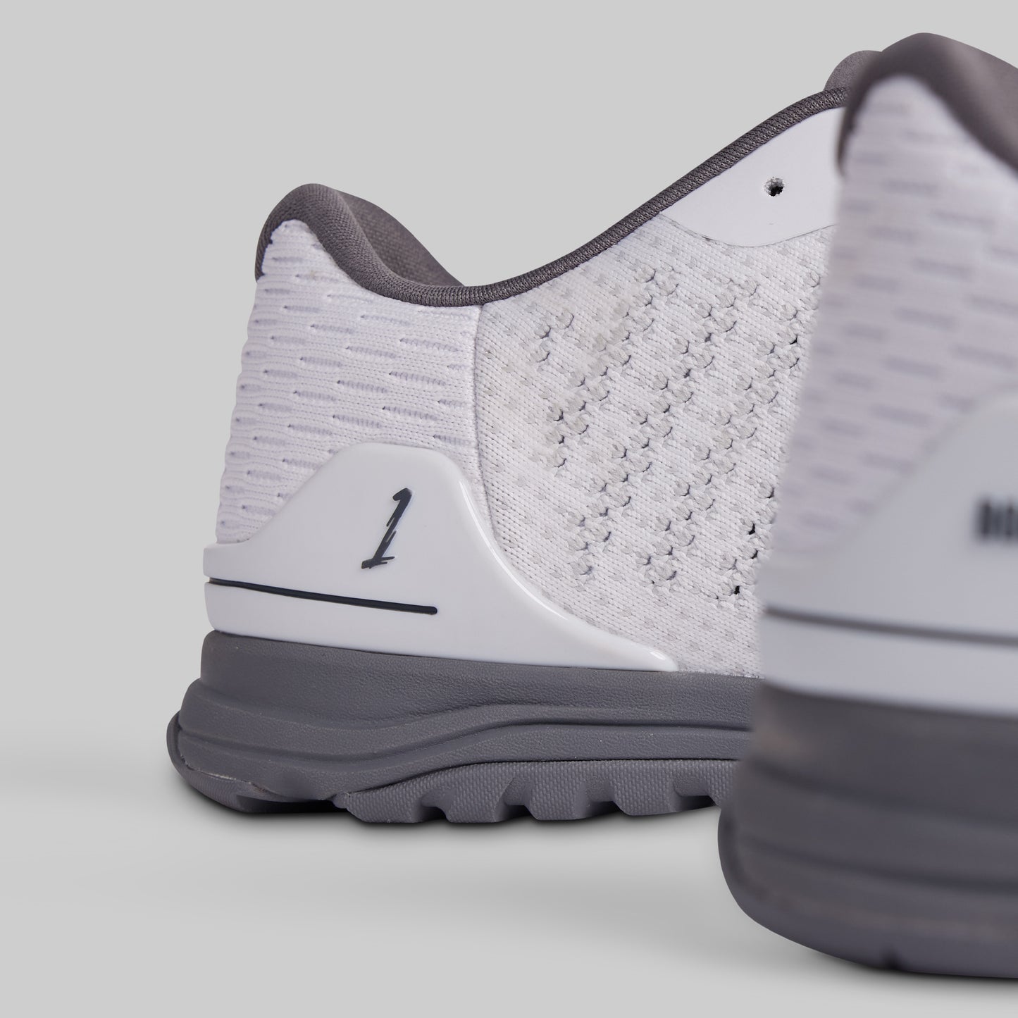 Close-up of a white and gray athletic shoe on a light gray background