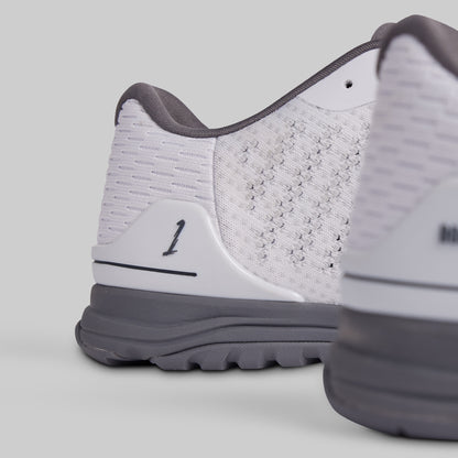 Close-up of a white and gray athletic shoe on a light gray background